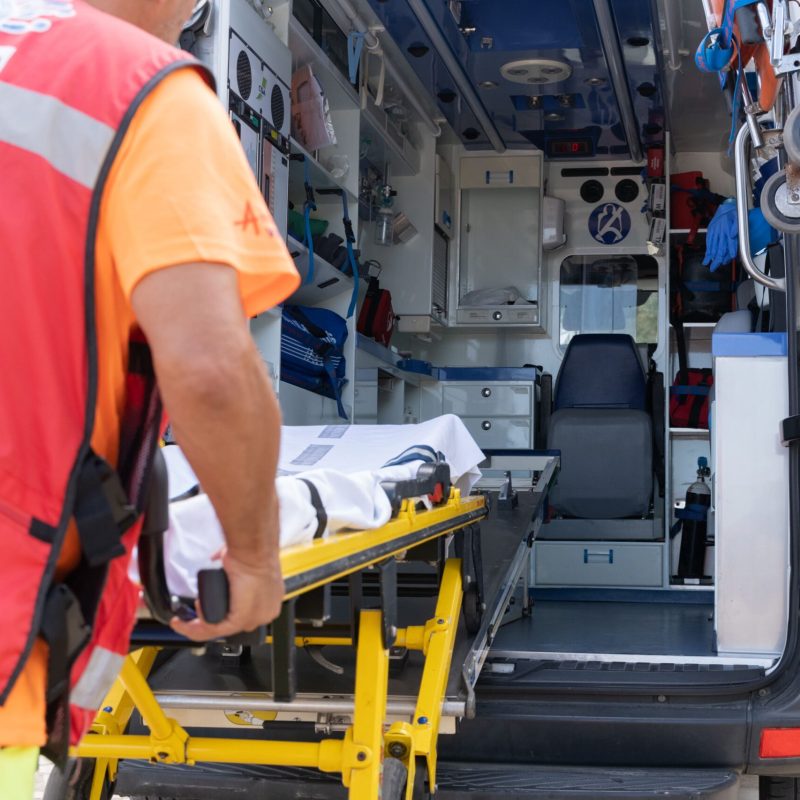 unrecognizable-lifeguard-worker-working-on-an-ambulance Operario introduciendo una camilla en la ambulancia